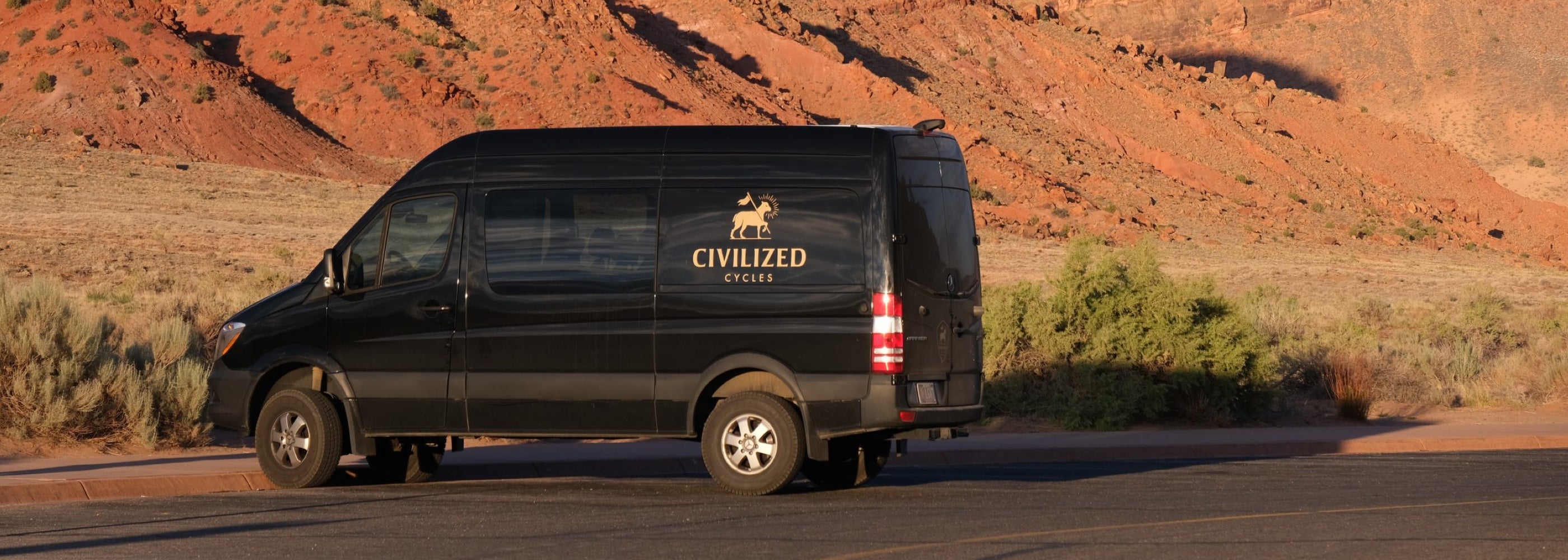 A Civ branded black van parked in the southwestern desert.